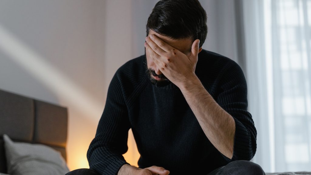 Homme ayant un problème d'érection et se tenant le visage
